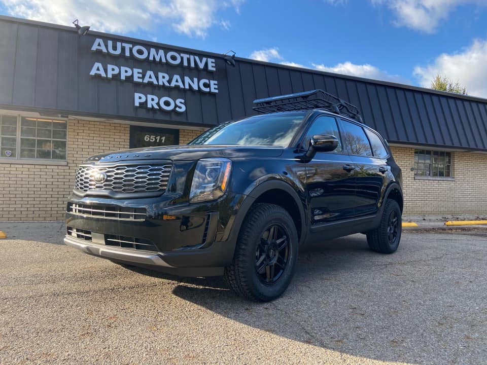 Black Kia with customization at the exterior of AAPR building