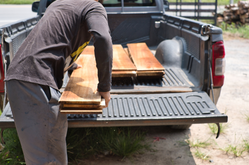 An owner is loading wood on his pick up truck