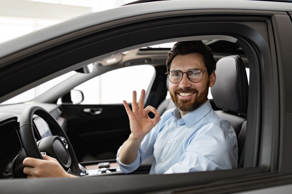 Business man sitting on the driver seat of the car